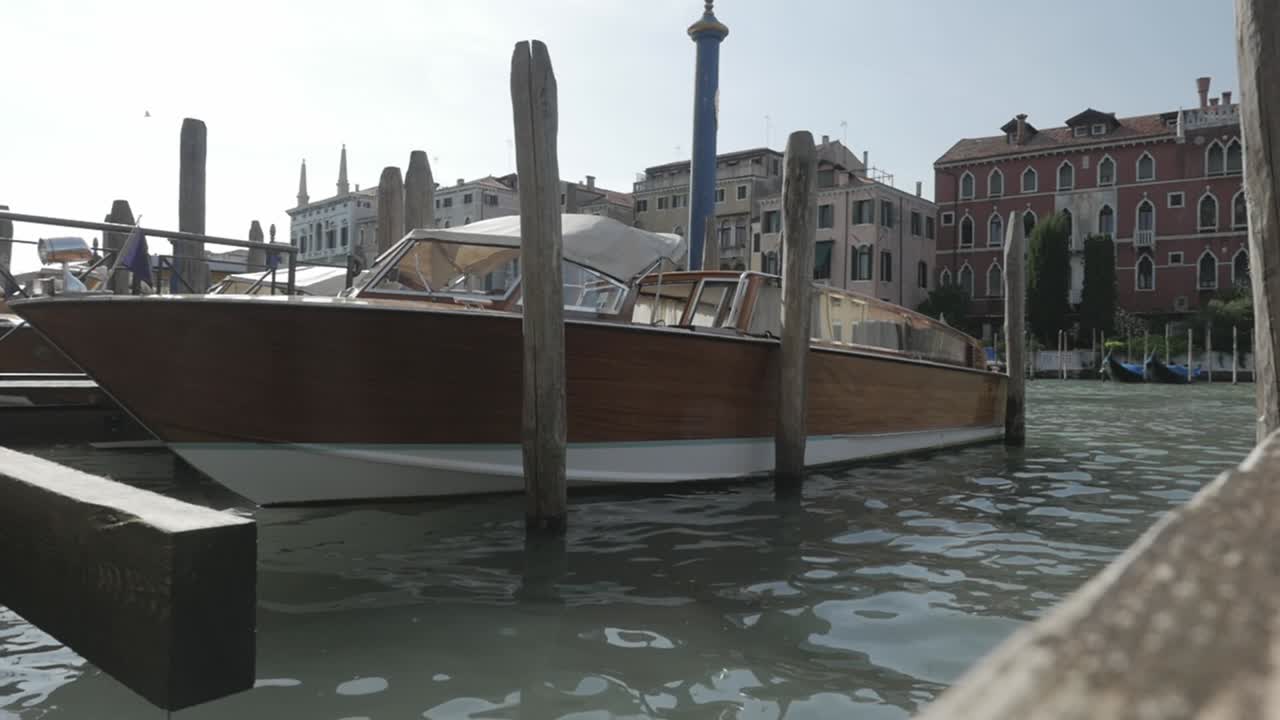 Brown wooden Speedboat moored on a pier in Venice, Italy