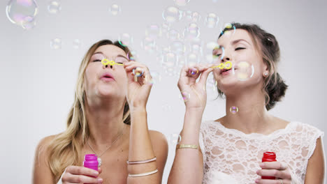 two women blowing bubbles slow motion wedding photo booth series