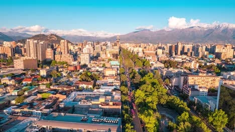 Hiperlapso-Aéreo-Del-Barrio-Brasileño-Hacia-El-Paisaje-Urbano-De-Santiago,-Montaña-De-Los-Andes-En-La-Distancia