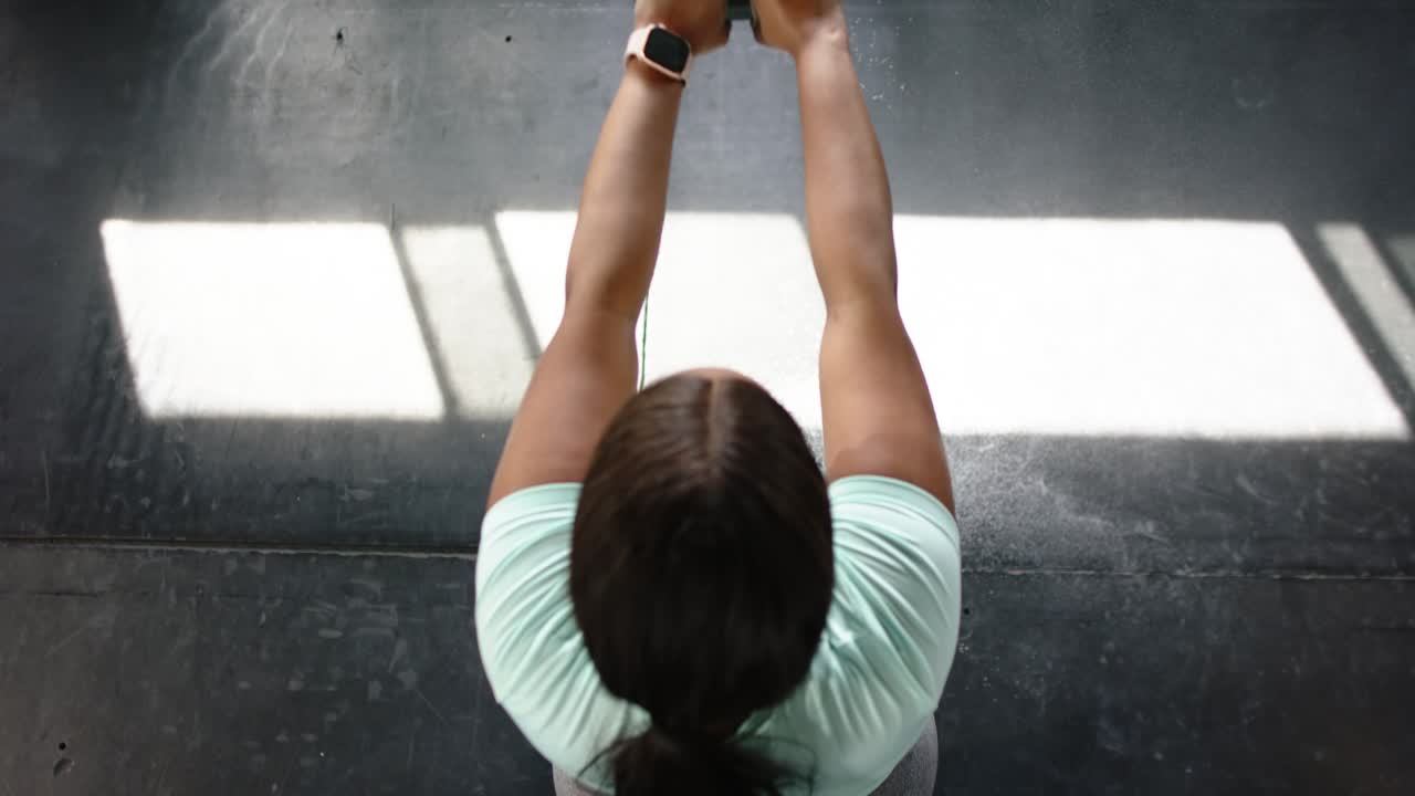 Noticing sunlight, woman is aligning on bench, lifting kettlebell, pressing overhead and lowering