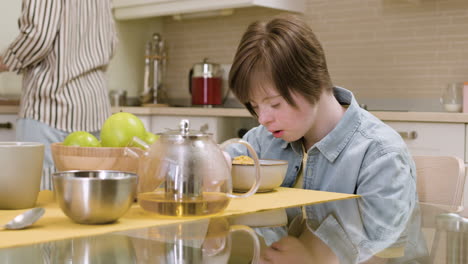 young girl with down syndrome eating cereals with milk while her mother is asking her how she feels