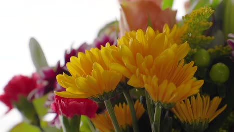 mooi boeket van kleurrijke bloemen met gele madeliefjes close-up van binnen naast zonnig raam met rood en paars arrangement