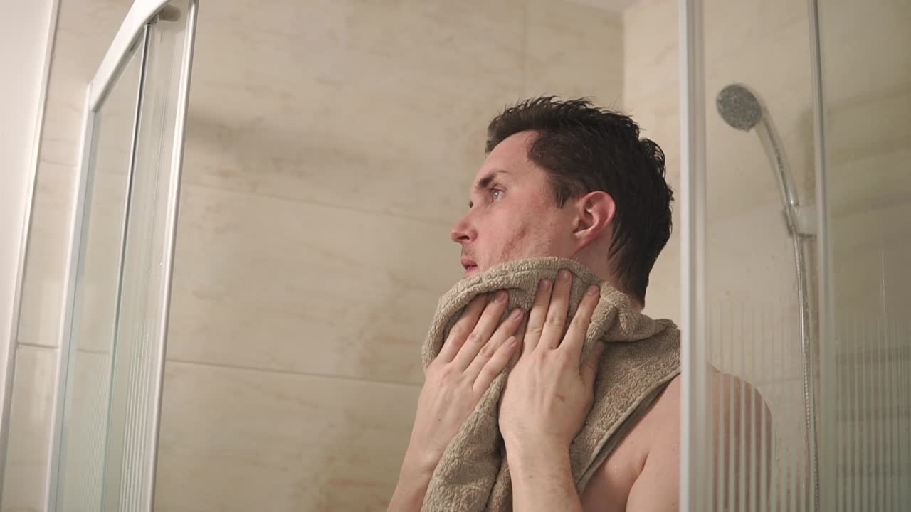 샤워실 에서 수건 으로 몸 을 건조 시키는 사람