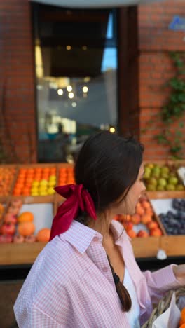 woman shopping for fruits at an outdoor market