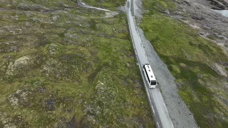 autobús turístico blanco que conduce a los turistas en el paso de montaña de vikafjellet en noruega - aero siguiendo el autobús desde arriba antes de inclinarse para revelar el paisaje hacia vik en sogn