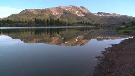 las montañas rocosas se reflejan perfectamente en un lago alpino 1