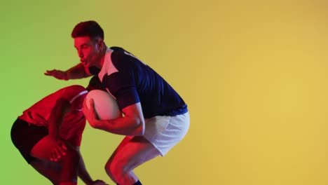Verschiedene-Männliche-Rugbyspieler-Mit-Rugbyball,-Der-über-Gelber-Beleuchtung-Spielt