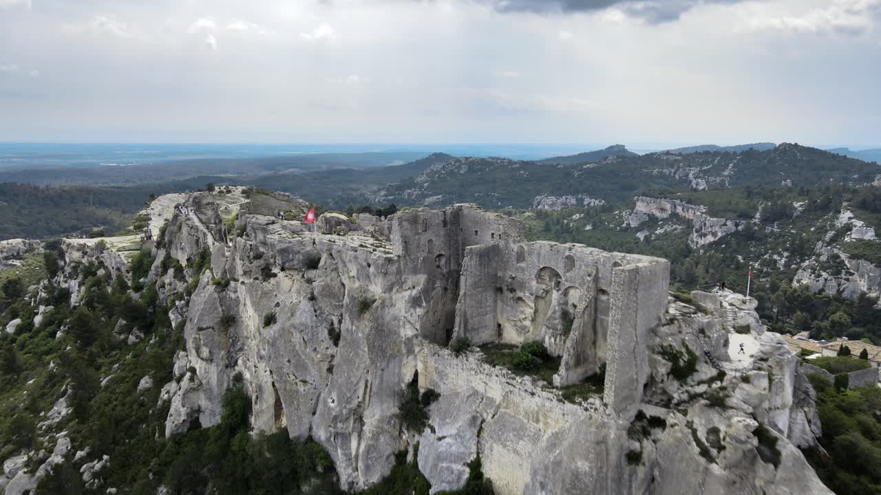 las ruinas del castillo blanco y gris en lo alto de los acantilados épicos en les baux de provence, francia, vista aérea