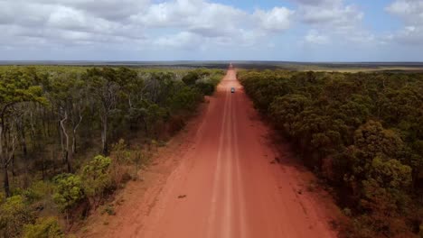 vista aérea de una polvorienta carretera de tierra recta con tráfico de vehículos en el remoto interior de australia