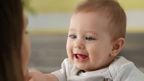 happy baby girl playing with her affectionate mum