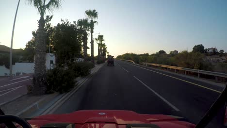 point of view driving at sunset down palm tree lined roads in cyprus