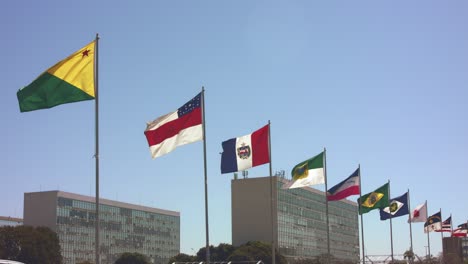 national state flags from many nations with various brazilian government ministry buildings in the background