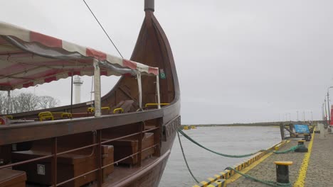 réplica de un barco vikingo que se balancea lentamente atracado en kolobrzeg, polonia