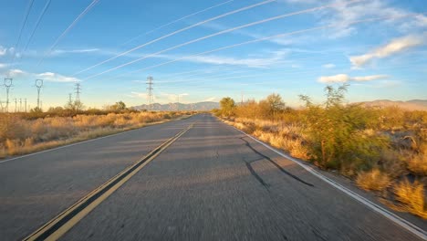 pov - driving on an asphalt road and under power transmission lines through sonoran desert in southern arizona