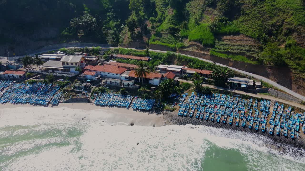 Many fisherman's boats moored and tropical beach of Menganti, aerial drone view