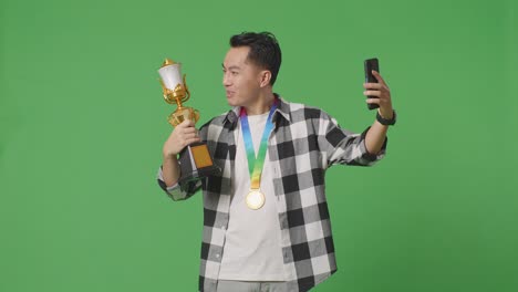 hombre celebrando una victoria de trofeo con selfie