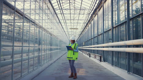 retrato de una ingeniera anotando información analizando la productividad de la fábrica