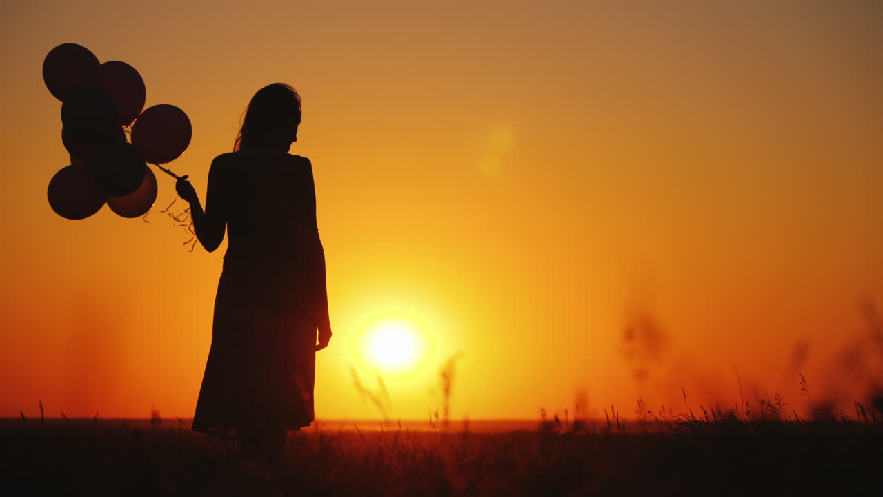 장난감을 손에 들고 평온한 아이가 일몰에 엄마에게 달려갑니다