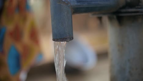 water running from waterpump tap africa clean drinking water from a traditional watertap - close up