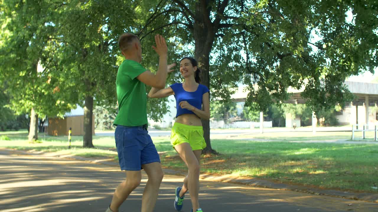 una pareja de corredores celebrando después de terminar el entrenamiento
