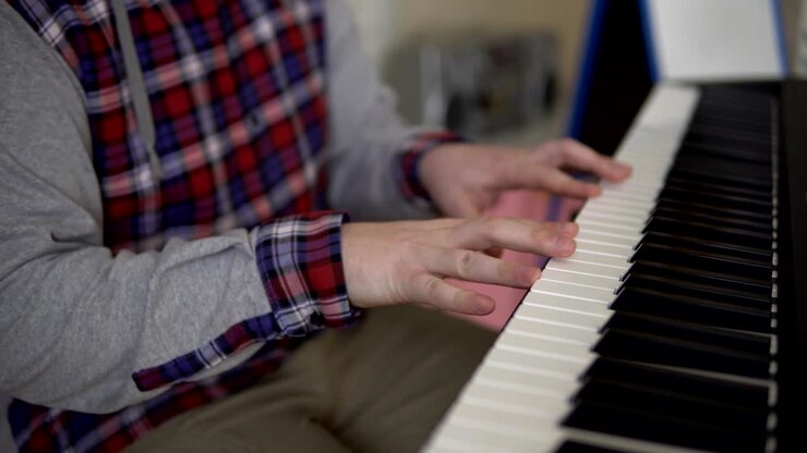Hands of men play on the electronic synthesizer