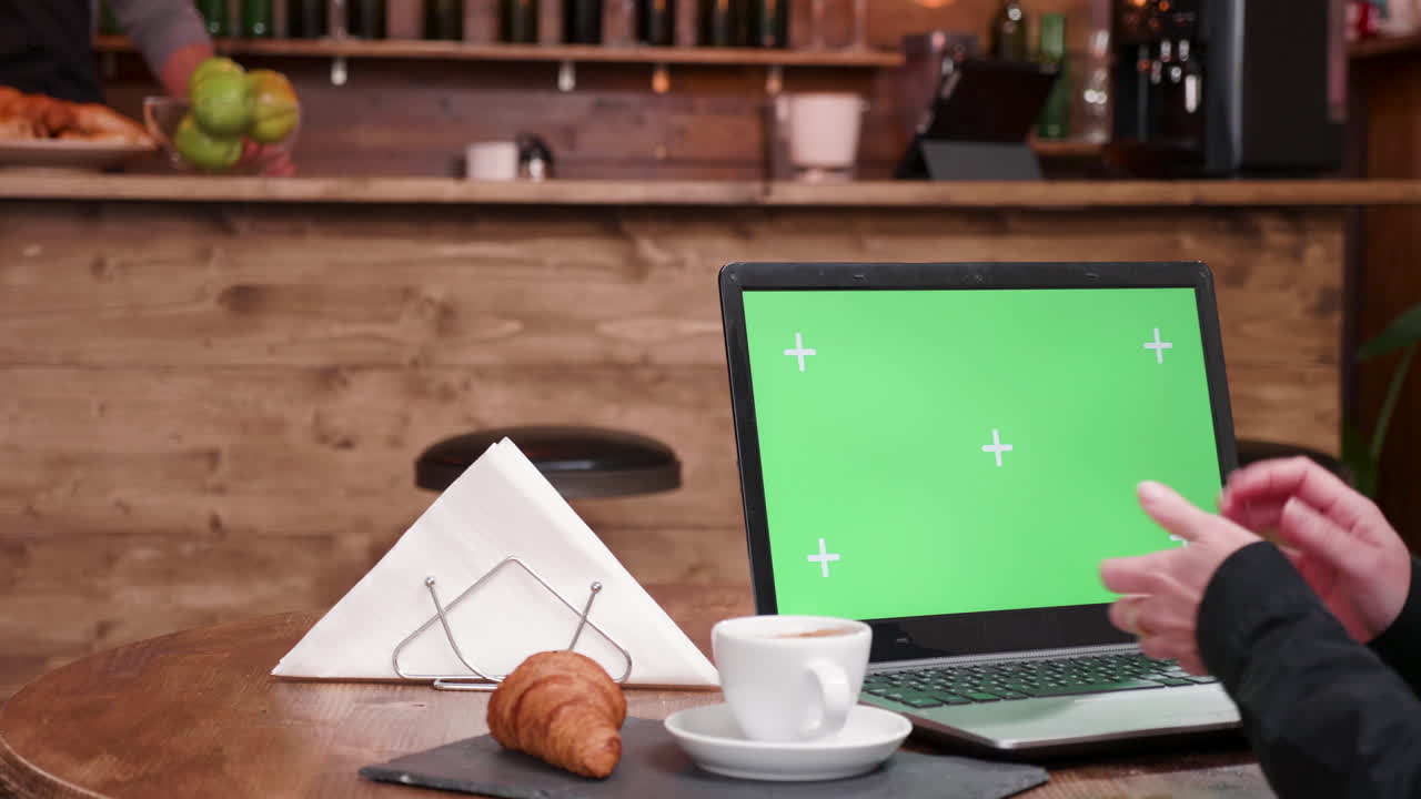 Laptop with green screen at a cafe