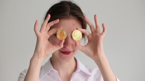 young woman holding bitcoin coins