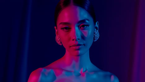 woman's portrait with dramatic red, blue, and purple lighting