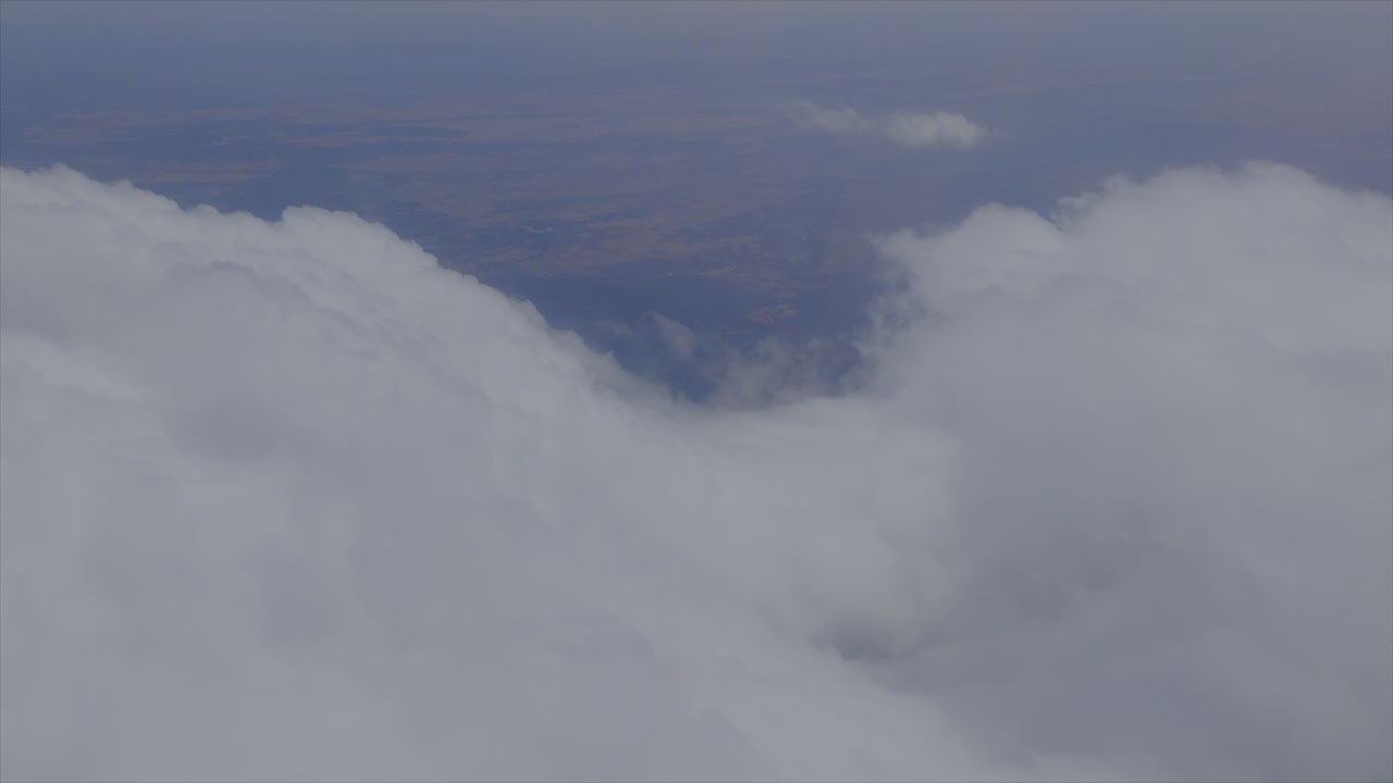 Looking out the window from an airplane at blue sky and clouds