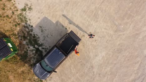 a drone descends from flight over a gravel parking lot.