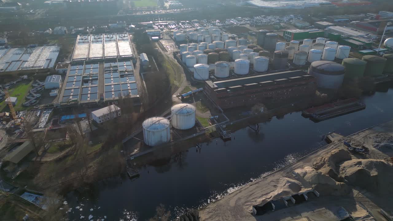 Wastewater treatment plant purifying urban water showing sedimentation tanks, aeration tanks and clarifiers. Smooth aerial view flight rotation to right drone