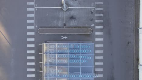 shopping cart storage with clear glass roof next to empty carpark of a supermarket