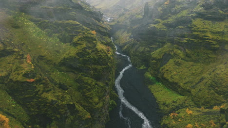 Flyover-above-winding-river-running-through-lush-green