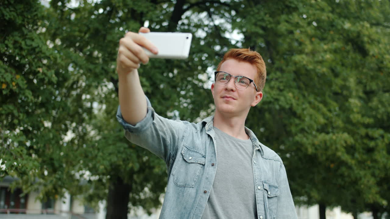 Happy Young Man Taking Selfies in a Park