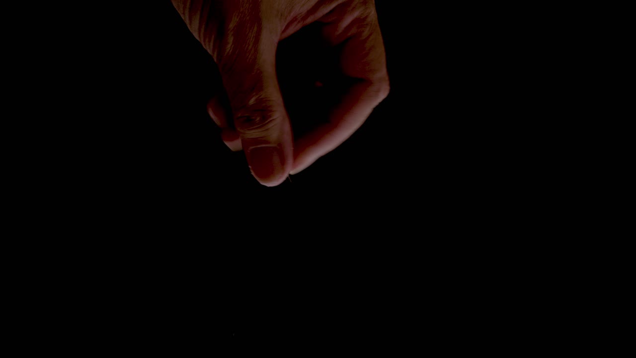 Sprinkling flaked almonds close up on a black backdrop slow motion