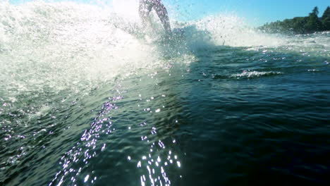 slow motion of wake surfer making a small cut while riding a wave