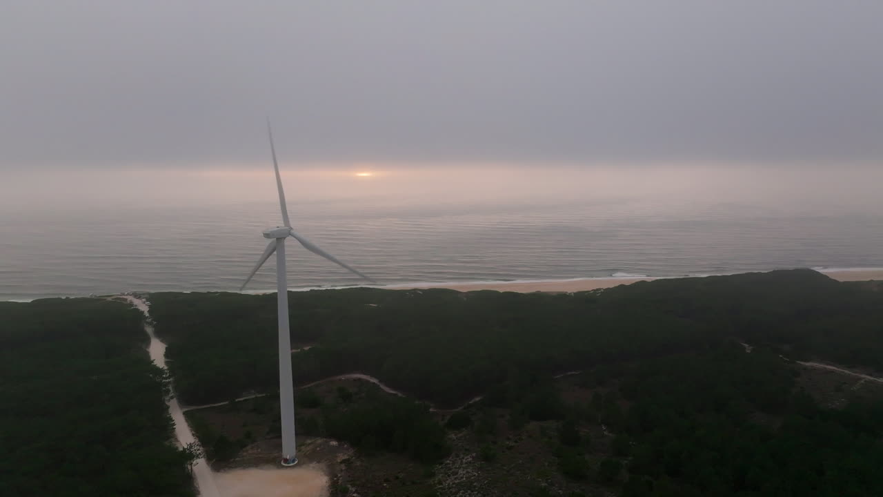 해가 뜨고 해가 지는 해안 풍경에 있는 풍력 터빈