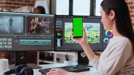 professional asian woman working on a media project next to green screen