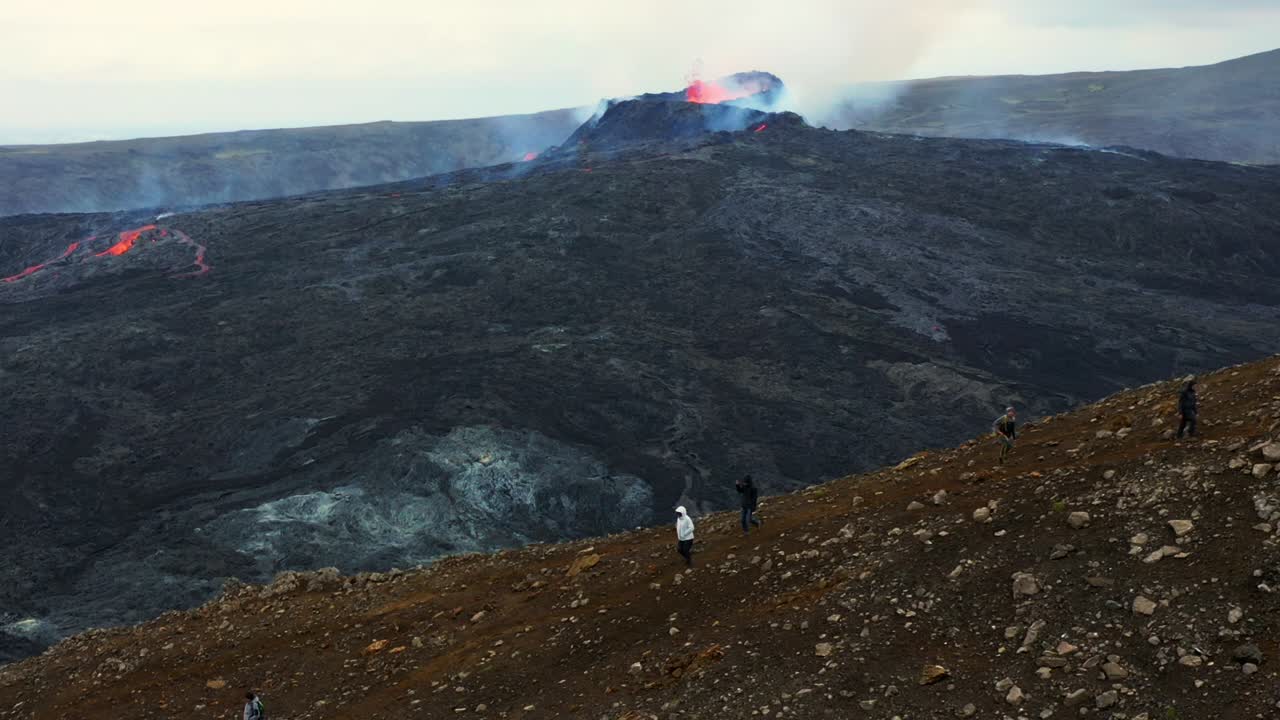 turistas observando el volcán fagradalsfjall durante la erupción - toma aérea de drones