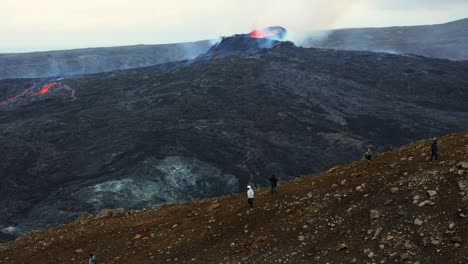 tourists watching the fagradalsfjall volcano during eruption - aerial drone shot