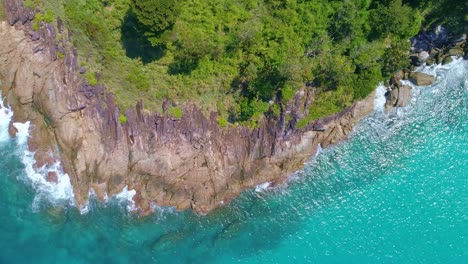 aerial view drone camera top down of seashore rocks in a blue ocean beautiful sea surface amazing sea waves crashing on rocks seascape aerial view drone 4k high quality of ocean with stone rock cliff