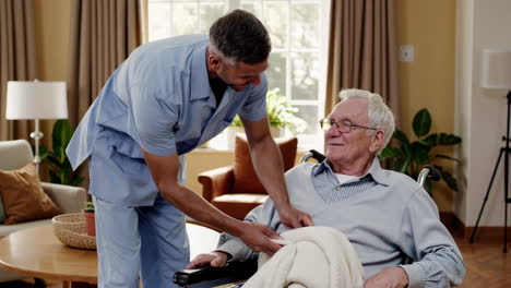 caregiver assisting an elderly man in a wheelchair with a blanket