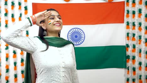 young indian girl looking up in the sky and saluting indian tricolor flag - celebrating independence day