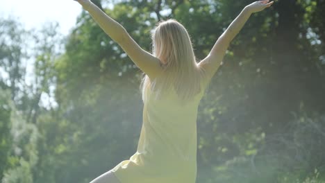 woman in yellow dress dancing gracefully in summer park