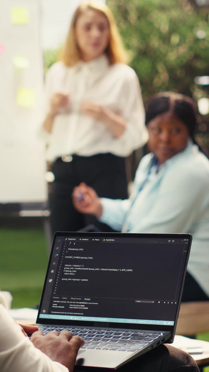 Vertical Video Black software developer working on programming code on laptop