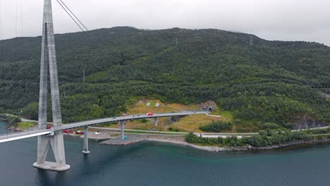 aerial: hålogaland bridge seen from the ofotfjord in narvik and an ore train in the background