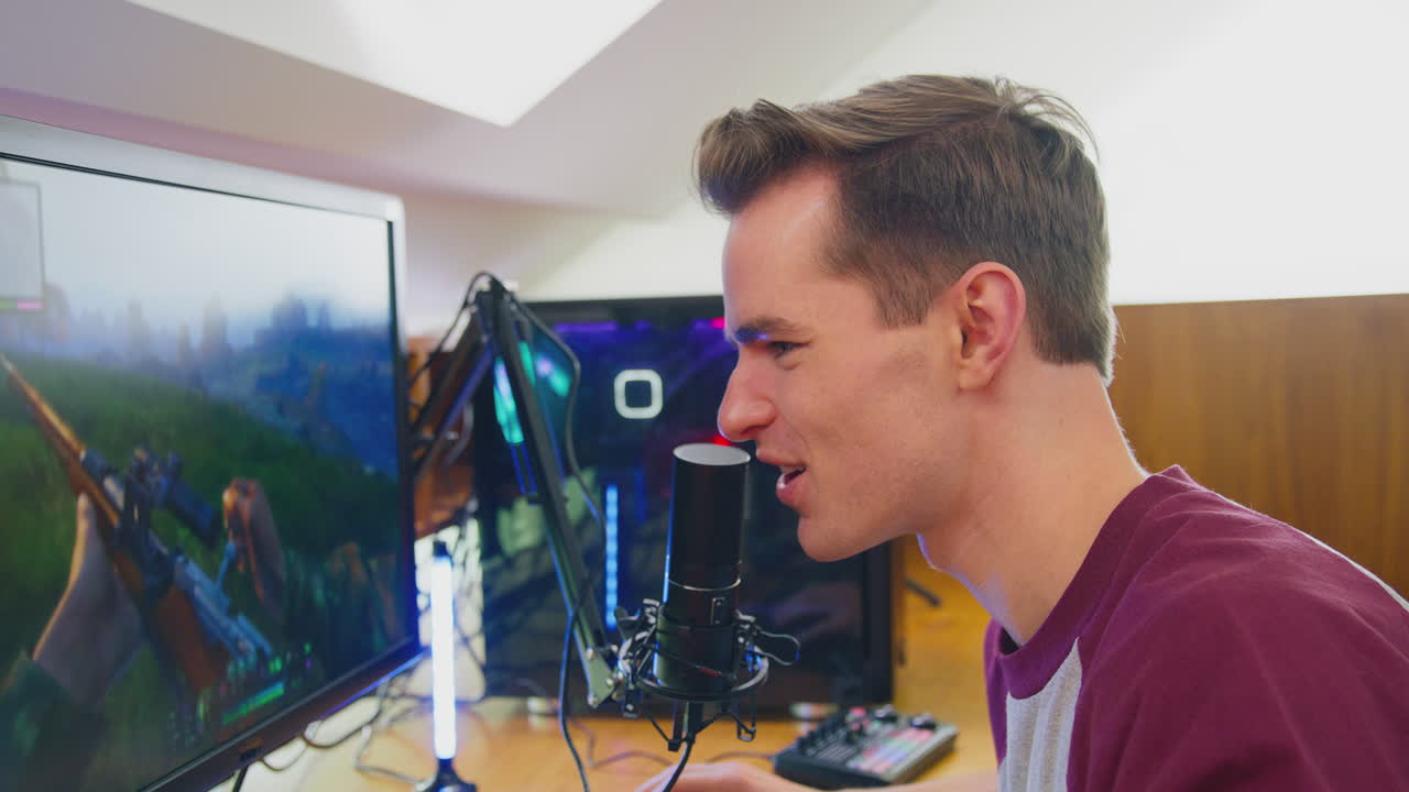 여러 모니터와 함께 책상에 앉아서 집에서 게임을 하는 남자