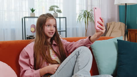 teenage girl taking a selfie on a sofa