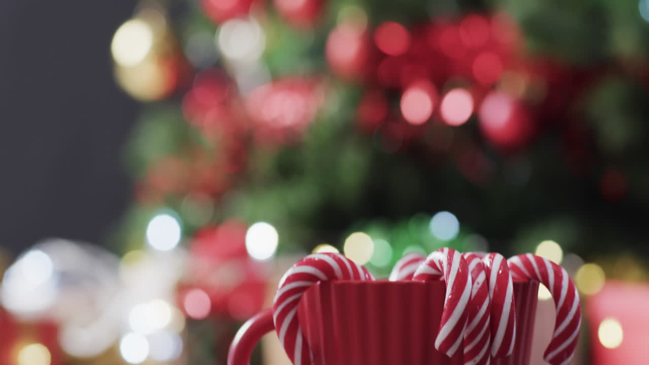 video de taza roja con bastones de navidad y luces de árbol de navidad con espacio de copia