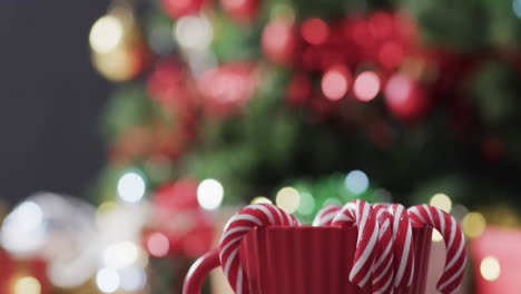 Video-Von-Einem-Roten-Becher-Mit-Weihnachtsstöcken-Und-Weihnachtsbaumbeleuchtung-Mit-Kopierraum